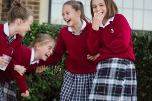 Four Prep School girls in the playground laughing